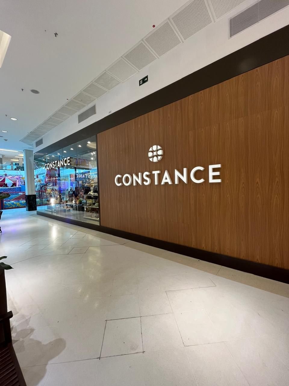 Fachada de loja em shopping com painel de madeira