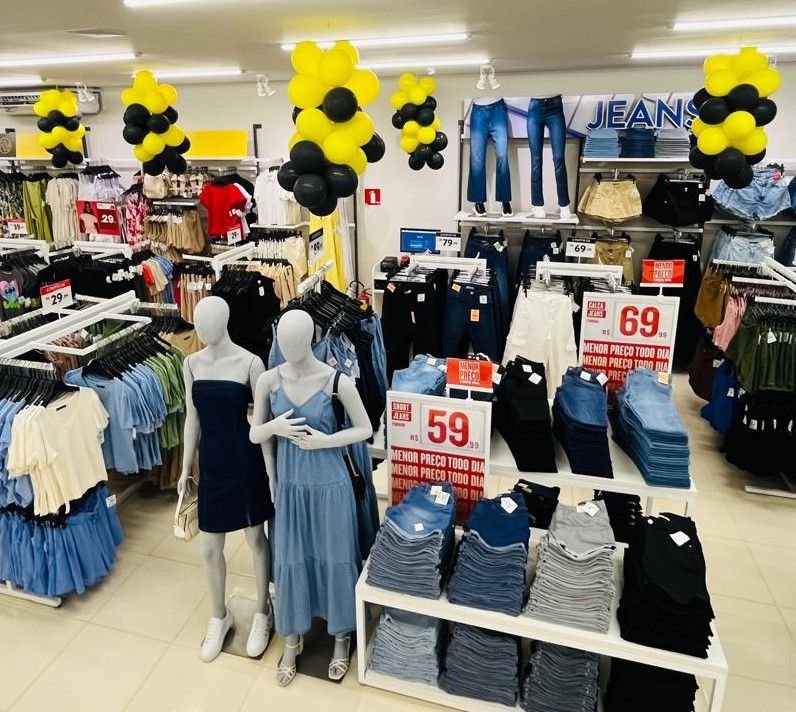 Loja de moda montada com araras, mesas expositoras e manequins